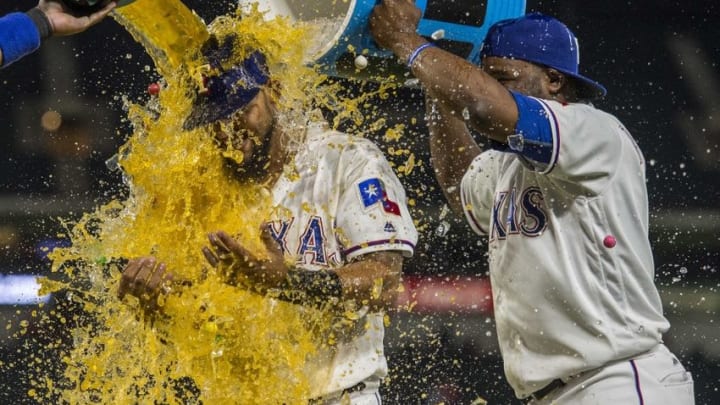 Apr 20, 2016; Arlington, TX, USA; Texas Rangers shortstop Hanser Alberto (2) and shortstop Elvis Andrus (1) pour water and Powerade and gum balls on second baseman Rougned Odor (12) after the win over the Houston Astros at Globe Life Park in Arlington. The Rangers defeat the Astros 2-1. Mandatory Credit: Jerome Miron-USA TODAY Sports