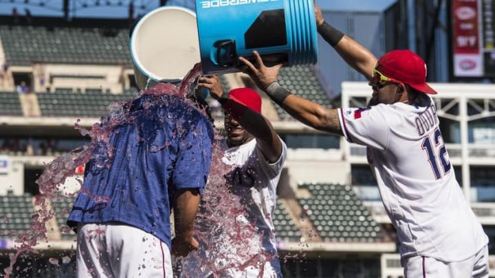 Aug 28, 2016; Arlington, TX, USA; Texas Rangers shortstop Elvis Andrus (1) and second baseman Rougned Odor (12) dump water and Powerade on starting pitcher Derek Holland (45) after defeating the Cleveland Indians 2-1 at Globe Life Park in Arlington. Mandatory Credit: Jerome Miron-USA TODAY Sports