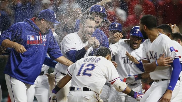 Aug 30, 2016; Arlington, TX, USA; Texas Rangers second baseman Rougned Odor (12) is mobbed by his teammates after hitting a game winning two run home run in the bottom of the ninth inning against the Seattle Mariners at Globe Life Park in Arlington. Texas won 8-7. Mandatory Credit: Tim Heitman-USA TODAY Sports