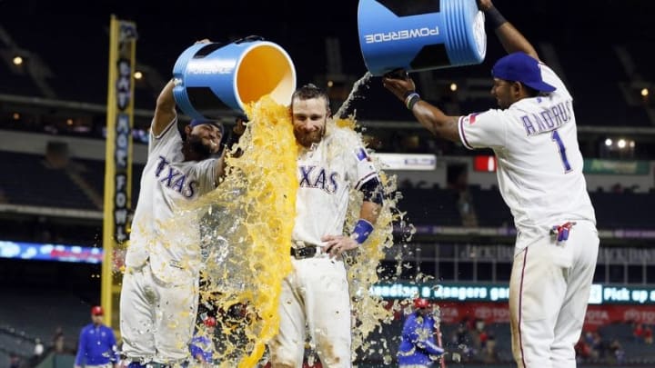 Sep 27, 2016; Arlington, TX, USA; Texas Rangers second baseman Rougned Odor (12) and shortstop Elvis Andrus (1) pour water and Powerade on catcher Jonathan Lucroy (25) after the game against the Milwaukee Brewers at Globe Life Park in Arlington. Texas won 6-4. Mandatory Credit: Tim Heitman-USA TODAY Sports