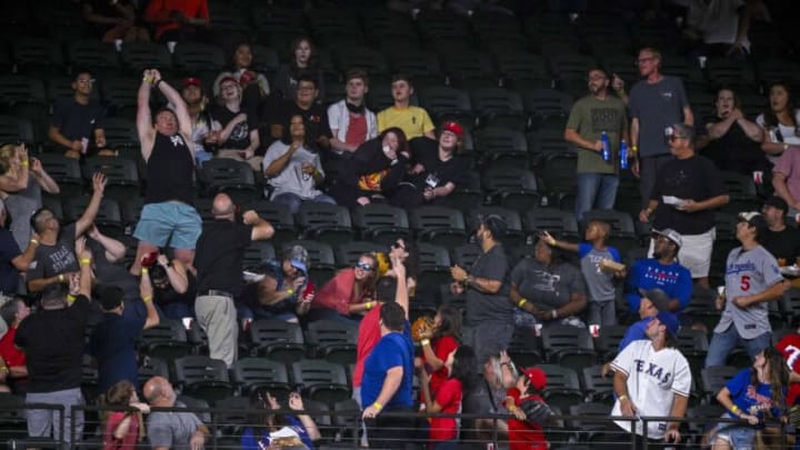 Sep 21, 2022; Arlington, Texas, USA; A fan attempts to catch a home run ball hit by Los Angeles Angels right fielder Taylor Ward (not pictured) during the first inning against the Texas Rangers at Globe Life Field. Mandatory Credit: Jerome Miron-USA TODAY Sports