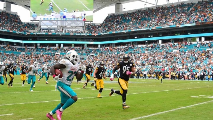 Oct 16, 2016; Miami Gardens, FL, USA; Miami Dolphins running back Jay Ajayi (23) eludes Pittsburgh Steelers outside linebacker Jarvis Jones (95) during the second half at Hard Rock Stadium. The Dolphins won 30-15. Mandatory Credit: Steve Mitchell-USA TODAY Sports