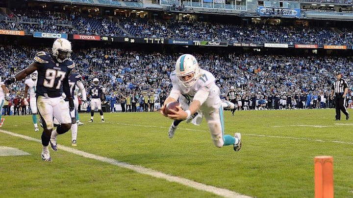 Dec 20, 2015; San Diego, CA, USA; Miami Dolphins quarterback Ryan Tannehill (17) dives in for a touchdown as San Diego Chargers outside linebacker Jeremiah Attaochu (97) defends during the fourth quarter at Qualcomm Stadium. Mandatory Credit: Jake Roth-USA TODAY Sports