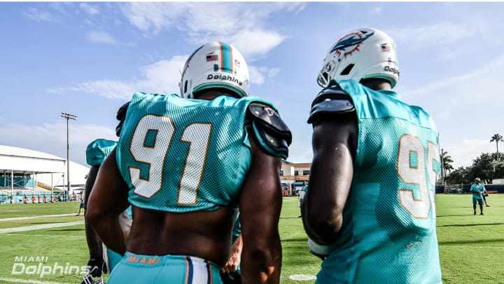 DE’s Cameron Wake and William Hayes talk at training camp practice – image courtesy of MiamiDolphins.com