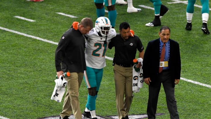 MINNEAPOLIS, MN - DECEMBER 16: Frank Gore #21 of the Miami Dolphins is helped off the field by team trainers in the second quarter of the game against the Minnesota Vikings at U.S. Bank Stadium on December 16, 2018 in Minneapolis, Minnesota. (Photo by Hannah Foslien/Getty Images)