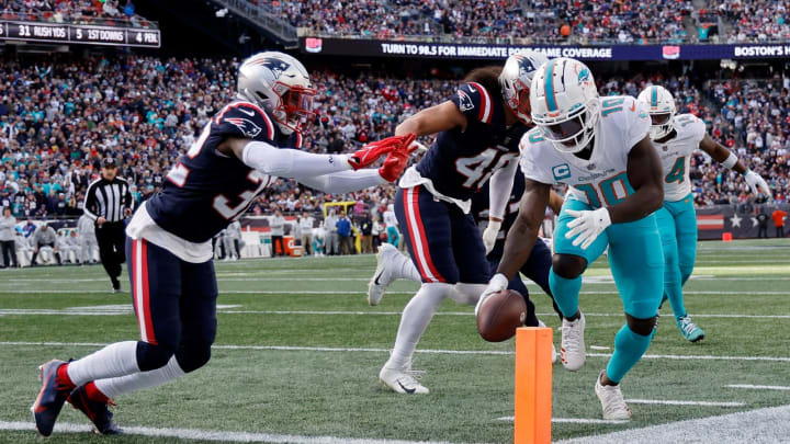 FOXBOROUGH, MASSACHUSETTS – JANUARY 01: Tyreek Hill #10 of the Miami Dolphins scores a touchdown against Devin McCourty #32 of the New England Patriots during the second quarter at Gillette Stadium on January 01, 2023 in Foxborough, Massachusetts. (Photo by Winslow Townson/Getty Images)