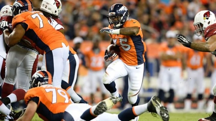 Sep 3, 2015; Denver, CO, USA; Denver Broncos running back Kapri Bibbs (35) runs behind the block of center Max Garcia (73) in the fourth quarter of a preseason game against the Arizona Cardinals at Sports Authority Field at Mile High. The Cardinals defeated the Broncos 22-20. Mandatory Credit: Ron Chenoy-USA TODAY Sports
