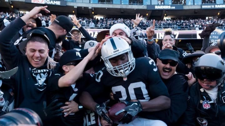Dec 24, 2016; Oakland, CA, USA; Oakland Raiders running back Jalen Edwards (30) leaps into the stands to celebrate with fans after a touchdown against the Indianapolis Colts during the second quarter at the Oakland Coliseum. Mandatory Credit: Kelley L Cox-USA TODAY Sports