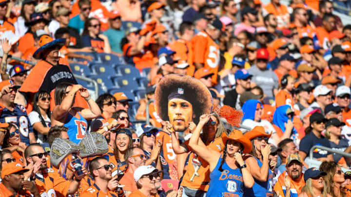 DENVER, CO - SEPTEMBER 29: Colorful and costumed broncos fans including one woman holding a large picture of the face of Phillip Lindsay #30 of the Denver Broncos cheer during the second quarter of a game against the Jacksonville Jaguars at Empower Field at Mile High on September 29, 2019 in Denver, Colorado. (Photo by Dustin Bradford/Getty Images)