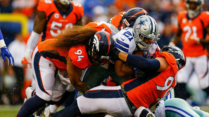 DENVER, CO - SEPTEMBER 17: Nose tackle Domata Peko #94 and defensive tackle Adam Gotsis #99 of the Denver Broncos tackle running back Ezekiel Elliott #21 of the Dallas Cowboys in the first half at Sports Authority Field at Mile High on September 17, 2017 in Denver, Colorado. (Photo by Justin Edmonds/Getty Images)