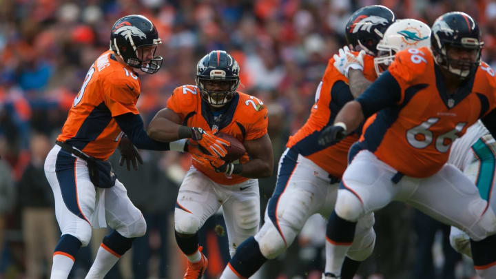 DENVER, CO – NOVEMBER 23: Quarterback Peyton Manning #18 of the Denver Broncos hands off to running back C.J. Anderson #22 during a game against the Miami Dolphinsat Sports Authority Field at Mile High on November 23, 2014 in Denver, Colorado. (Photo by Dustin Bradford/Getty Images)