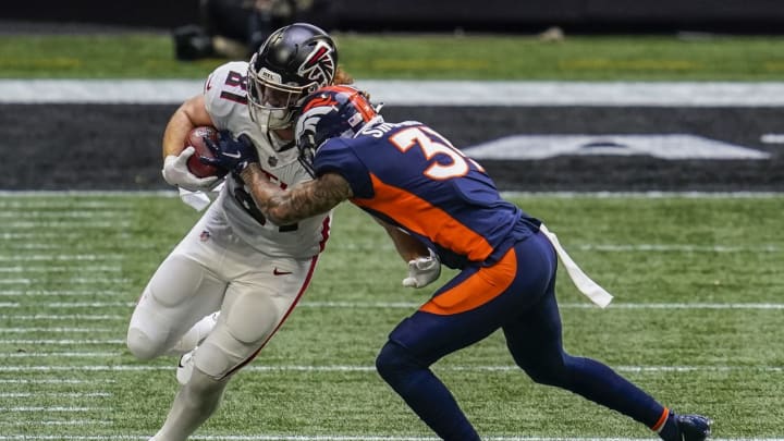 Nov 8, 2020; Atlanta, Georgia, USA; Atlanta Falcons tight end Hayden Hurst (81) is tackled by Denver Broncos safety Justin Simmons (31) during the first half at Mercedes-Benz Stadium. Mandatory Credit: Dale Zanine-USA TODAY Sports