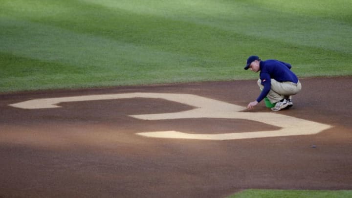 MINNEAPOLIS, MN - MAY 23: Heads groundskeeper Larry DiVito for the Minnesota Twins puts finishing touches to Hall of Famer Harmon Killebrew's number behind second base prior to a game between the Seattle Mariners and the Minnesota Twins on May 23, 2011 at Target Field in Minneapolis, Minnesota. Harmon Killebrew passed away on May 17, 2011 after a battle with esophageal cancer. (Photo by Hannah Foslien/Getty Images)