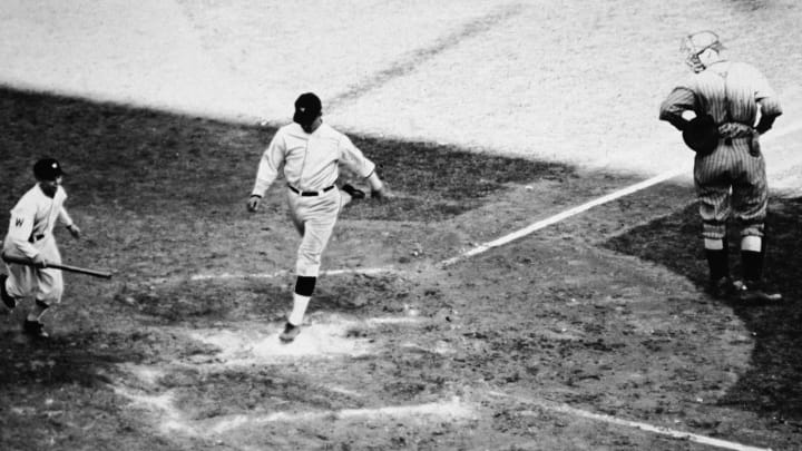 American baseball player Stanley “Bucky” Harris (1896- 1977), playing for the Washington Senators, lands on home plate after scoring a homerun during the seventh game of the World Series at Griffith Stadium, Washington, D.C., October 10, 1924. Washington won the game and the series. (Photo by Credit: APA/Getty Images)
