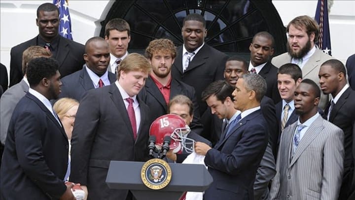 Apr 15, 2013; Washington, D.C., USA; United State president Barack Obama accepts a helmet from Alabama Crimson Tide football offensive lineman Barrett Jones during a photo opportunity for the BCS Championship team at the White House. Mandatory Credit: H.Darr Beiser-USA TODAY Sports