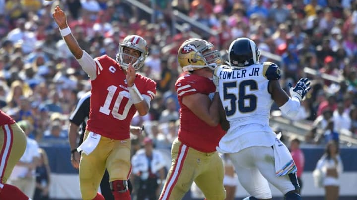 LOS ANGELES, CA - OCTOBER 13: Jimmy Garoppolo #10 of the San Francisco 49ers throws a pass while Justin Skule #67 blocks Dante Fowler #56 of the Los Angeles Rams in the third quarter at Los Angeles Memorial Coliseum on October 13, 2019 in Los Angeles, California. (Photo by John McCoy/Getty Images)