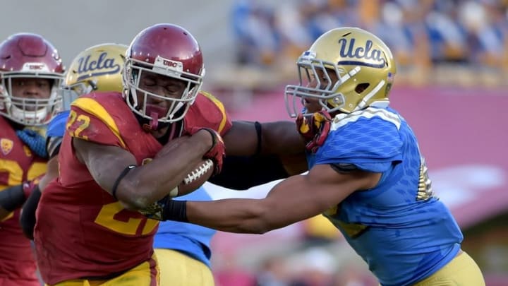 Nov 28, 2015; Los Angeles, CA, USA; Southern California Trojans running back Justin Davis (22) is defended by UCLA Bruins linebacker Kenny Young (42) during an NCAA football game at Los Angeles Memorial Coliseum. USC defeated UCLA 40-21. Mandatory Credit: Kirby Lee-USA TODAY Sports