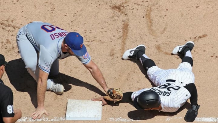 CHICAGO, ILLINOIS - AUGUST 01: Leury Garcia #28 of the Chicago White Sox dives safely back to first base ahead of the tag by Pete Alonso #20 of the New York Mets in the 6th inning at Guaranteed Rate Field on August 01, 2019 in Chicago, Illinois. (Photo by Jonathan Daniel/Getty Images)