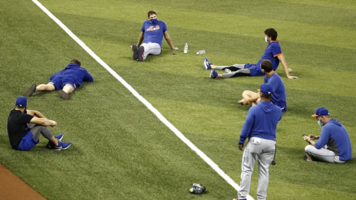 MIAMI, FLORIDA - AUGUST 20: Members of the New York Mets socially distance on the field after the game between the New York Mets and the Miami Marlins was postponed due to a member of the Mets organization testing positive for COVID-19 at Marlins Park on August 20, 2020 in Miami, Florida. (Photo by Michael Reaves/Getty Images)