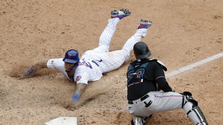 NEW YORK, NEW YORK - AUGUST 31: Javier Baez #23 of the New York Mets slides home with the game winning run in the ninth inning against Alex Jackson #23 of the Miami Marlins at Citi Field on August 31, 2021 in New York City. This is a continuation of the April 11 game which was suspended due to inclement weather. (Photo by Jim McIsaac/Getty Images)