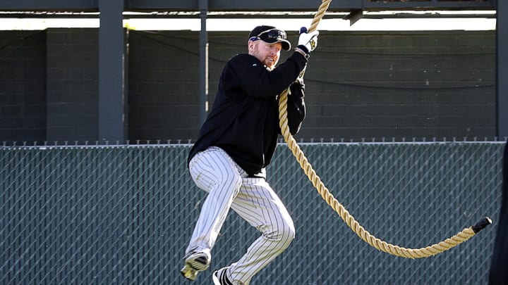 Rockies pitcher Aaron Cook sings from a rope.