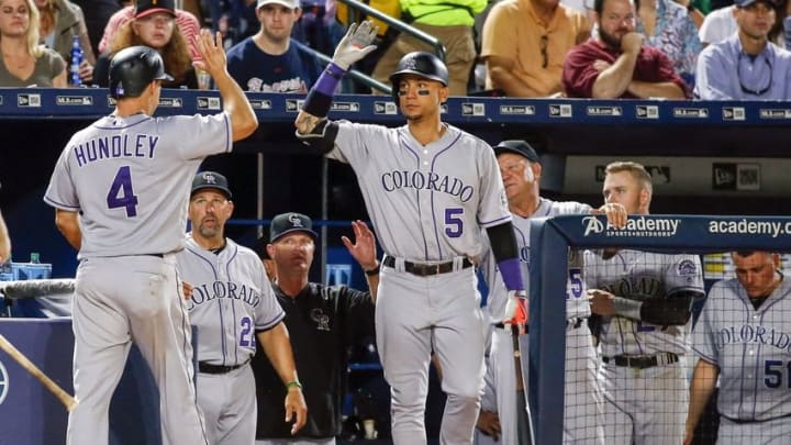 Jul 16, 2016; Atlanta, GA, USA; Colorado Rockies catcher Nick Hundley (4) is congratulated by right fielder Carlos Gonzalez (5) after scoring a run against the Atlanta Braves in the eighth inning at Turner Field. Mandatory Credit: Brett Davis-USA TODAY Sports