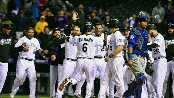 Aug 19, 2016; Denver, CO, USA; Colorado Rockies first basemen Ryan Raburn (6) (center) and catcher Nick Hundley (4) celebrate scoring on a throwing error to end the game in the eleventh inning against the Chicago Cubs at Coors Field. The Rockies defeated the Cubs 7-6 in 11 innings. Mandatory Credit: Ron Chenoy-USA TODAY Sports