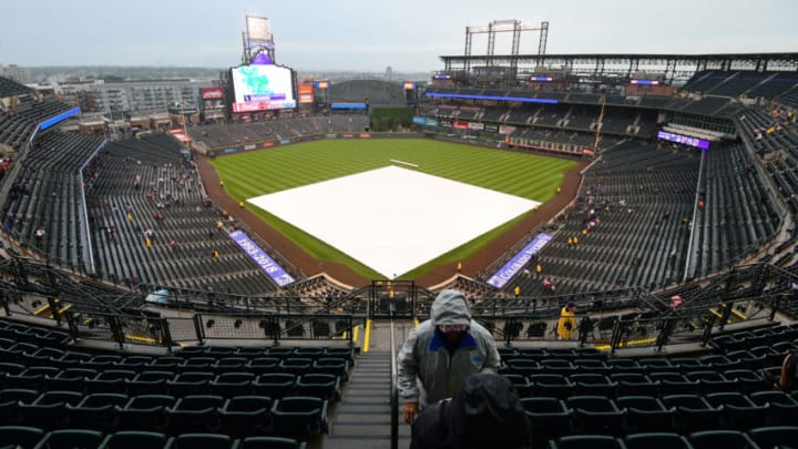 DENVER, CO - SEPTEMBER 5: Fans search for cover during a rain delay before a baseball game against the Colorado Rockies and the San Francisco Giants on September 5, 2018 at Coors Field in Denver, Colorado. (Photo by Julio Aguilar/Getty Images)
