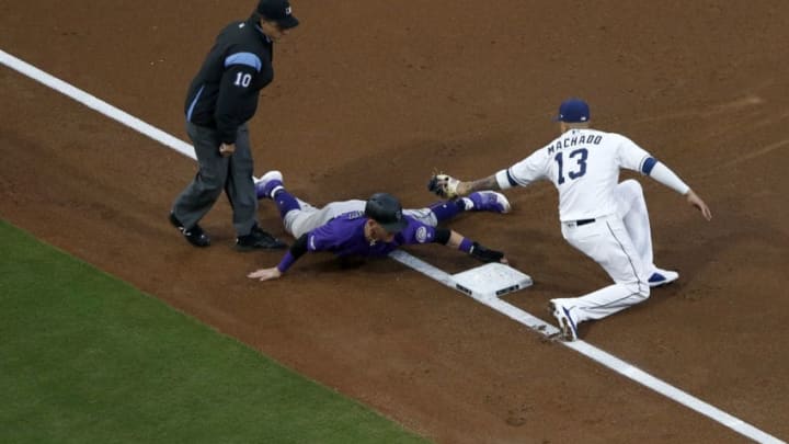SAN DIEGO, CALIFORNIA - APRIL 16: Trevor Story #27 of the Colorado Rockies safely steals third base as Manny Machado #13 of the San Diego Padres places a late tag during the third inning of a game at PETCO Park on April 16, 2019 in San Diego, California. (Photo by Sean M. Haffey/Getty Images)