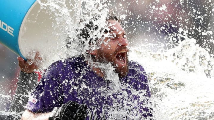 DENVER, COLORADO - MAY 30: Daniel Murphy #9 of the Colorado Rockies is doused with water by Tony Wolters #14 after hitting a RBI walk off single in the tenth inning against the Arizona Diamondbacks at Coors Field on May 30, 2019 in Denver, Colorado. (Photo by Matthew Stockman/Getty Images)