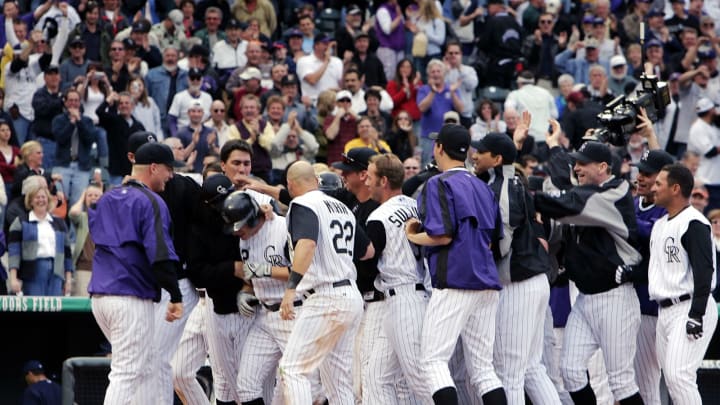 DENVER – APRIL 4: Clint Barmes #12 of the Colorado Rockies is swarmed by his teammates after hitting a walk-off game-winning home run against the San Diego Padres in the bottom of the ninth inning at Coors Field on opening day on April 4, 2005 in Denver, Colorado. The Rockies won 12-10. (Photo by Brian Bahr/Getty Images)