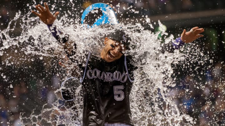 DENVER, CO - SEPTEMBER 26: Carlos Gonzalez #5 of the Colorado Rockies is drenched by a teammate after hitting a walk-off 2-run home run to put the Rockies ahead of the Dodgers 8-6 at Coors Field on September 26, 2015 in Denver, Colorado. (Photo by Dustin Bradford/Getty Images)