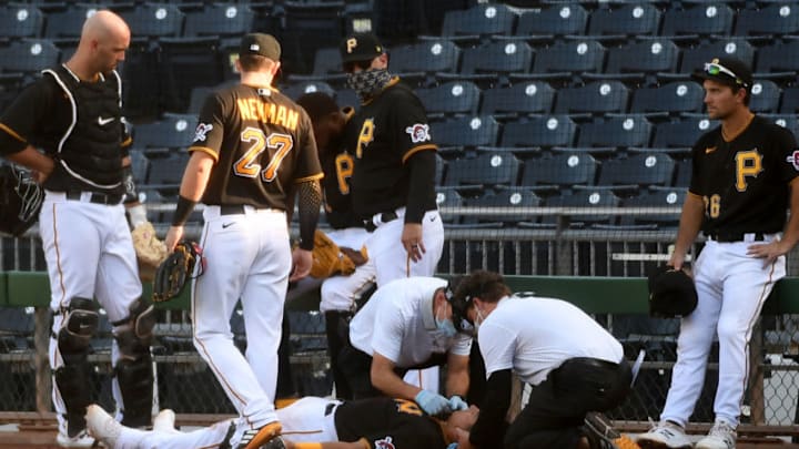 PITTSBURGH, PA - AUGUST 08: Phillip Evans #64 of the Pittsburgh Pirates is tended to by Pirates trainers after a collision with teammate Gregory Polanco #25 in the sixth inning during the game against the Detroit Tigers at PNC Park on August 8, 2020 in Pittsburgh, Pennsylvania. (Photo by Justin Berl/Getty Images)