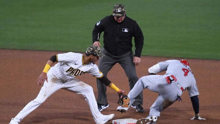 May 14, 2021; San Diego, California, USA; St. Louis Cardinals catcher Yadier Molina (4) slides into second base ahead of the tag by San Diego Padres second baseman Tucupita Marcano (L) after hitting a double during the fourth inning as umpire Greg Gibson (C) looks on at Petco Park. Mandatory Credit: Orlando Ramirez-USA TODAY Sports
