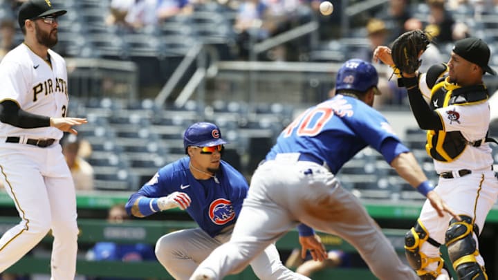 May 27, 2021; Pittsburgh, Pennsylvania, USA; Pittsburgh Pirates first baseman Will Craig (left) chases Chicago Cubs shortstop Javier Baez (9) in a run-down between home plate and first base allowing catcher Willson Contreras (40) to score a run as Pirates catcher Michael Perez (right) takes a throw during the third inning at PNC Park. Mandatory Credit: Charles LeClaire-USA TODAY Sports