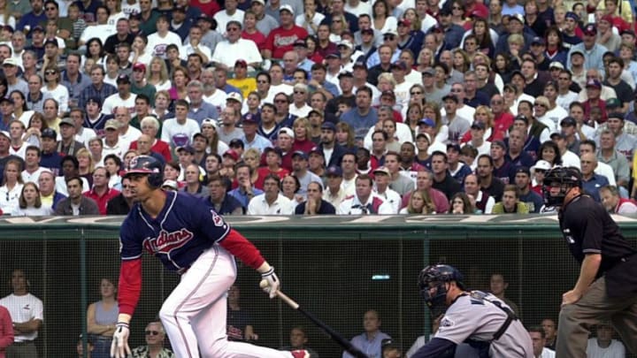 Cleveland Indians right fielder Juan Gonzalez (L), Seattle Mariners catcher Dan Wilson (C) and home plate umpire Paul Schrieber (R) watch Gonzalez' lead-off home run off of Seattle Mariners pitcher Paul Abbott during the third inning of the American League Division Series playoff game on 13 October 2001 at Jacobs Field in Cleveland, OH. Cleveland defeated Seattle 17-2. AFP PHOTO/David MAXWELL (Photo by DAVID MAXWELL / AFP) (Photo by DAVID MAXWELL/AFP via Getty Images)