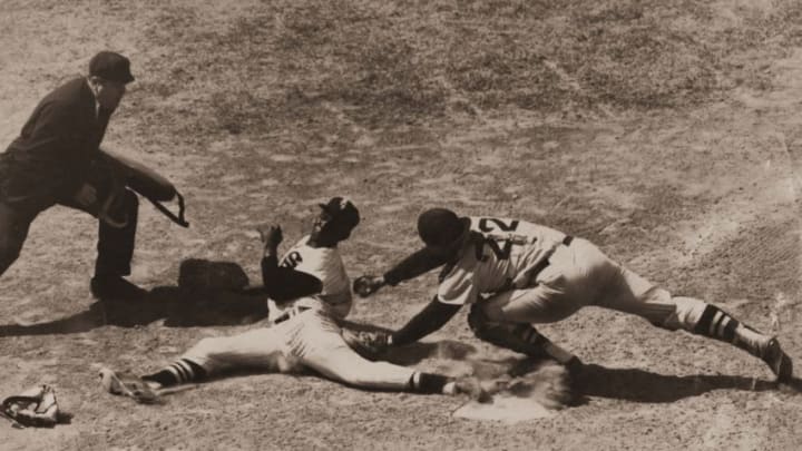 Minnie Minoso (L) of the Chicago White Sox slides around Boston catcher Sammy White in a 1953 game. (Photo by Mark Rucker/Transcendental Graphics, Getty Images)