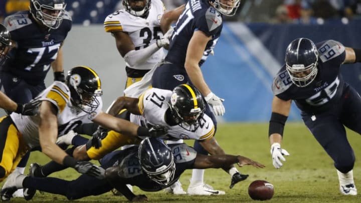 NASHVILLE, TENNESSEE - AUGUST 25: Akeem Hunt #35 of the Tennessee Titans reaches for a fumbled ball beneath Marcus Allen #27 of the Pittsburgh Steelers during the second half of a preseason game at Nissan Stadium on August 25, 2019 in Nashville, Tennessee. (Photo by Frederick Breedon/Getty Images)