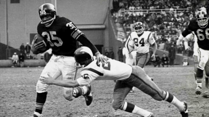 Hall of Fame halfback John Henry Johnson of the Pittsburgh Steelers runs upfield as fellow hall of famer Paul Krause attempts to tackle in a 14 to 7 win over the Washington Redskins on December 6, 1964 at D. C. Stadium in Washington DC. (Photo by Nate Fine/Getty Images) *** Local Caption ***