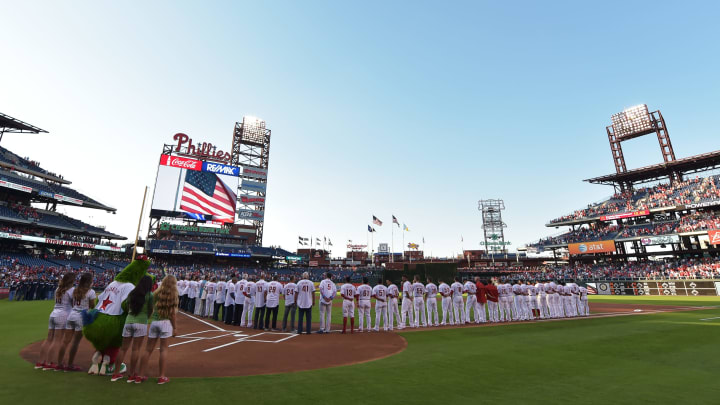 PHILADELPHIA, PA – AUGUST 01: Philadelphia Phillies alumni and present players observe the national anthem before the game against the Atlanta Braves at Citizens Bank Park on August 1, 2015 in Philadelphia, Pennsylvania. (Photo by Drew Hallowell/Getty Images)
