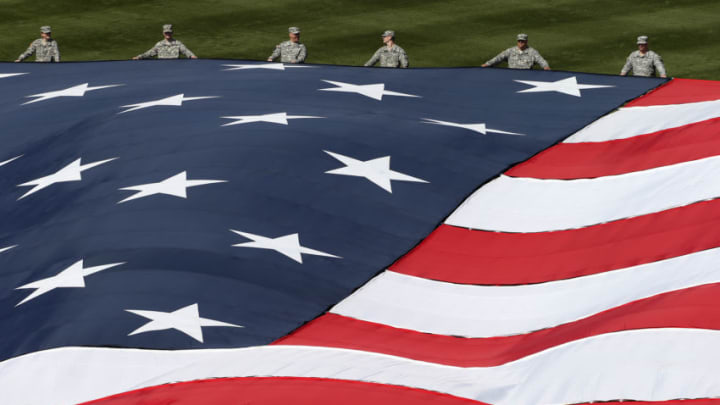 Servicemen hold a giant American flag at a Philadelphia Phillies game (Photo by Rich Schultz/Getty Images)