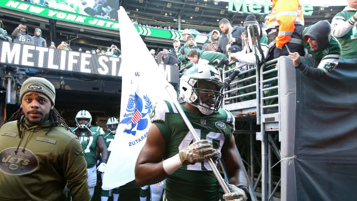 EAST RUTHERFORD, NEW JERSEY – NOVEMBER 11: Jordan Jenkins #48 of the New York Jets carries a military flag on to the field prior to the game against the Buffalo Bills at MetLife Stadium on November 11, 2018 in East Rutherford, New Jersey. (Photo by Michael Owens/Getty Images)