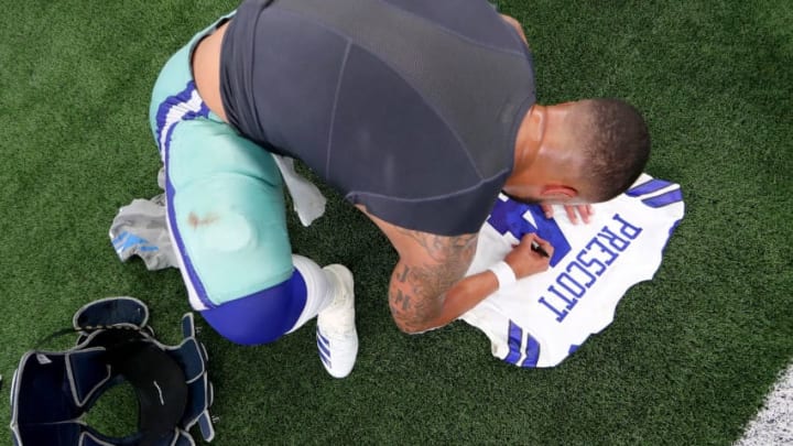 ARLINGTON, TX - SEPTEMBER 30: Dak Prescott #4 of the Dallas Cowboys signs his jersey after beating the Detroit Lions 26-24 at AT&T Stadium on September 30, 2018 in Arlington, Texas. (Photo by Tom Pennington/Getty Images)