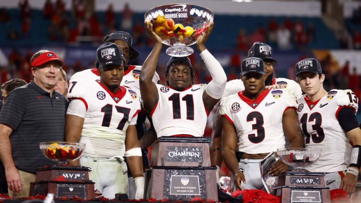 MIAMI GARDENS, FLORIDA – DECEMBER 31: Derion Kendrick #11 of the Georgia Bulldogs lifts the Orange Bowl trophy to teammates after the Georgia Bulldogs defeated the Michigan Wolverines 3-11 in the Capital One Orange Bowl for the College Football Playoff semifinal game at Hard Rock Stadium on December 31, 2021 in Miami Gardens, Florida. (Photo by Michael Reaves/Getty Images)