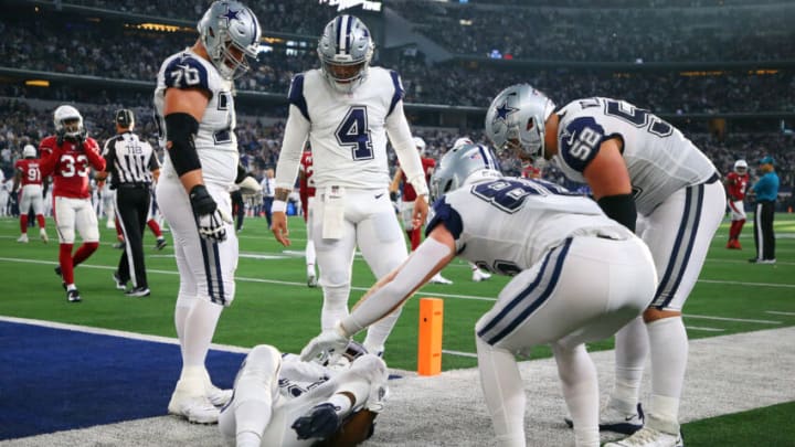 ARLINGTON, TEXAS - JANUARY 02: Dak Prescott #4 and other member of the Dallas Cowboys offense check on Michael Gallup #13 who was injured after catching a pass for a touchdown during the second quarter against the Arizona Cardinals at AT&T Stadium on January 02, 2022 in Arlington, Texas. (Photo by Richard Rodriguez/Getty Images)