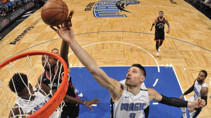 ORLANDO, FL – DECEMBER 28: Nikola Vucevic #9 of the Orlando Magic and Serge Ibaka #9 of the Toronto Raptors reach for the rebound during the game on December 28, 2018 at Amway Center in Orlando, Florida. NOTE TO USER: User expressly acknowledges and agrees that, by downloading and or using this photograph, User is consenting to the terms and conditions of the Getty Images License Agreement. Mandatory Copyright Notice: Copyright 2018 NBAE (Photo by Fernando Medina/NBAE via Getty Images)