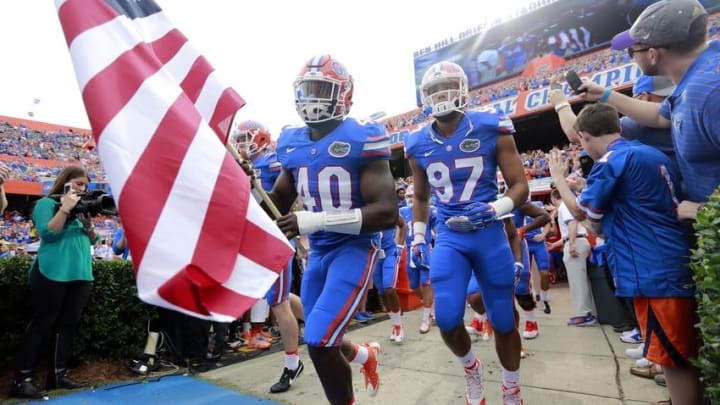 Nov 21, 2015; Gainesville, FL, USA; Florida Gators linebacker Jarrad Davis (40), defensive lineman Justus Reed (97) and teammates hold a flag as they run out of the tunnel before the game against the Florida Atlantic Owls at Ben Hill Griffin Stadium. Mandatory Credit: Kim Klement-USA TODAY Sports