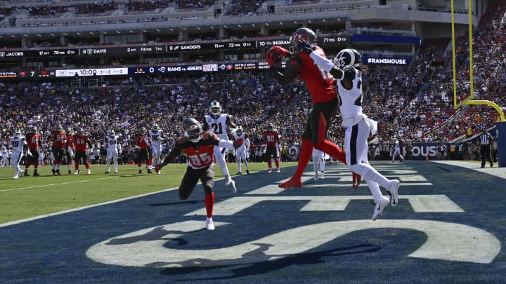 LOS ANGELES, CA – SEPTEMBER 29: Chris Godwin #12 of the Tampa Bay Buccaneers leaps up for a touchdown reception agaisnt Aqib Talib #21 of the Los Angeles Rams in the second quarter at Los Angeles Memorial Coliseum on September 29, 2019 in Los Angeles, California. (Photo by John McCoy/Getty Images)