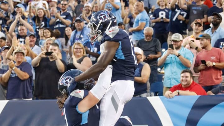 NASHVILLE, TN - AUGUST 18: Dennis Kelly #71 of the Tennessee Titans picks up teammate Taywan Taylor #13 to congratulate him for scoring a touchdown against the Tampa Bay Buccaneers during the first half of a pre-season game at Nissan Stadium on August 18, 2018 in Nashville, Tennessee. (Photo by Frederick Breedon/Getty Images)
