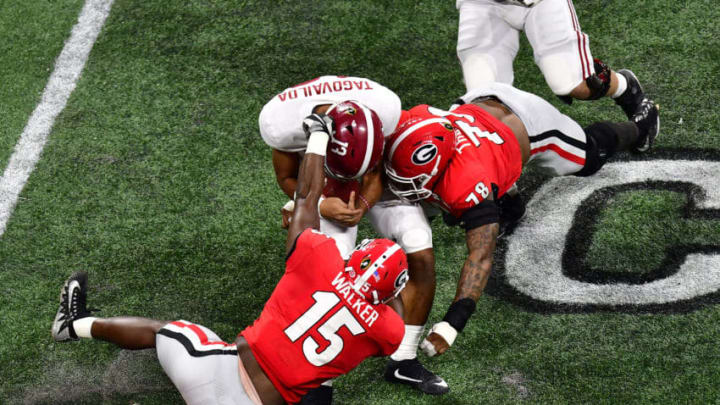 ATLANTA, GA - JANUARY 08: Tua Tagovailoa #13 of the Alabama Crimson Tide is tackled by D'Andre Walker #15 and Trenton Thompson #78 of the Georgia Bulldogs in the CFP National Championship presented by AT&T at Mercedes-Benz Stadium on January 8, 2018 in Atlanta, Georgia. (Photo by Scott Cunningham/Getty Images)
